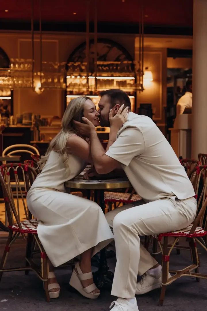 Couple kissing Paris cafe terrace white outfits summer