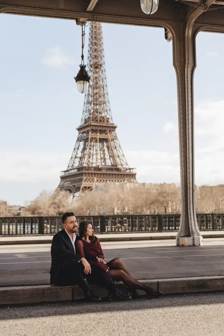 Couple sitting Bir-Hakeim bridge Eiffel Tower Paris