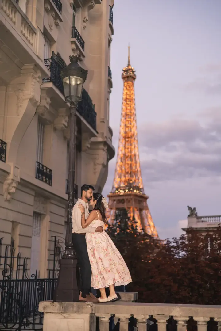 Couple Eiffel Tower evening lights balcony floral dress Paris