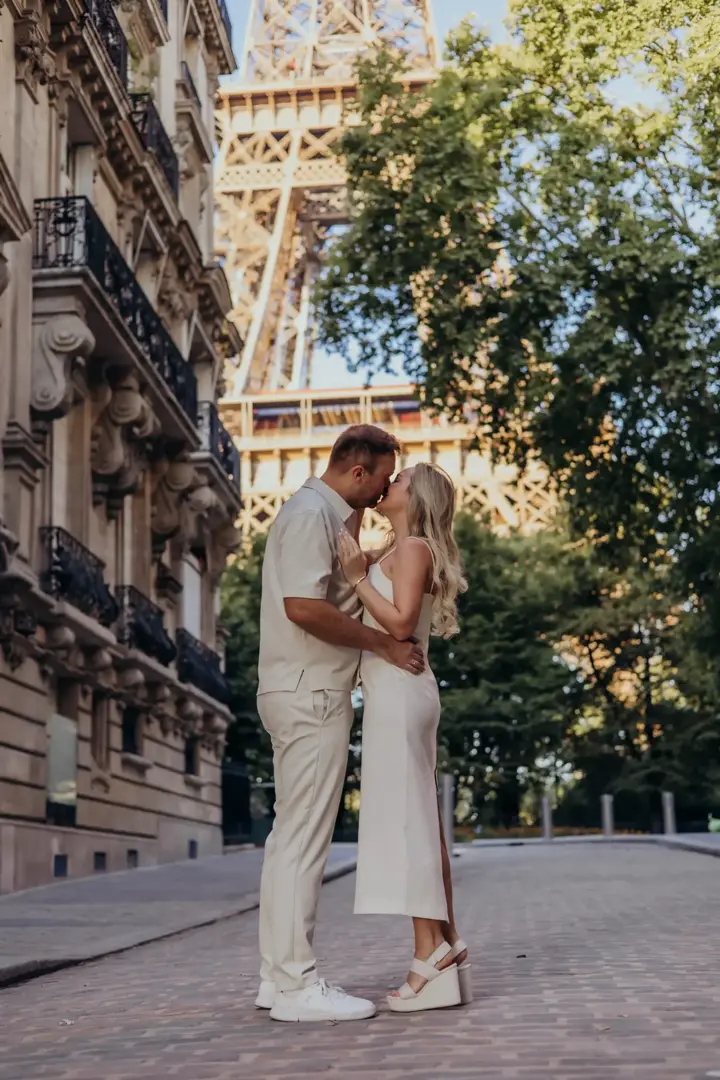 Couple kissing Eiffel Tower summer white outfits Paris