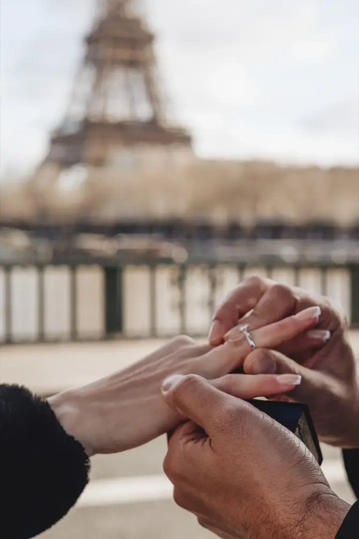 Putting engagement ring on finger Eiffel Tower Paris